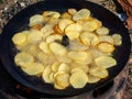 Frying potatoes in oil on a improvised pan Royalty Free Stock Photo