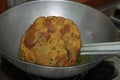 Frying a rounded and crisp Indian- Poori till it gets crispy and golden brown in the oil pan