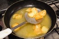 Frying rounded potatoes on a black pan with boiling oil Royalty Free Stock Photo