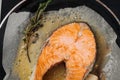 Frying salmon steak on parchment paper with butter