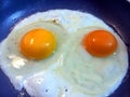 Frying two eggs different colored yolks