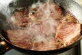 Frying veal in a pan with vapour