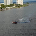 A US Coast Guard boat escorts a cruise ship into or out of port from the ocean channel