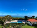 Empty resort or condo pool next to the ocean with palm trees on a  beautiful sunny blue sky day Royalty Free Stock Photo