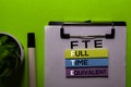 FTE. Full Time Equivalent acronym on sticky notes. Office desk background