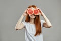 Fubby red-haired girl with grapefruit on her eyes