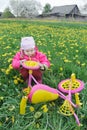 Fuchsia color kids trike with yellow wheels and little toddler girl exploring vehicle