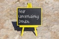 FUD fear uncertainty doubt symbol. Concept words FUD fear uncertainty doubt on black chalk blackboard on a beautiful stone Royalty Free Stock Photo