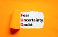 FUD fear uncertainty doubt symbol. Concept words FUD fear uncertainty doubt on white paper on a beautiful orange background. Royalty Free Stock Photo