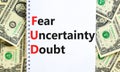 FUD fear uncertainty doubt symbol. Concept words FUD fear uncertainty doubt on white note on a beautiful background from dollar