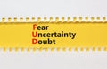 FUD fear uncertainty doubt symbol. Concept words FUD fear uncertainty doubt on white paper on a beautiful yellow background. Royalty Free Stock Photo