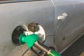 Fuel dispenser, green nozzle refueling car at the pump in gas station, close up