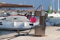 Fuel distributor on the pier of a gas station in the Mediterranean marina against the backdrop of sailing yachts. Refualing boats Royalty Free Stock Photo