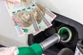 Fuel filler with inserted refueling gun and 500 poland zloty banknotes in hand, Concept of rising gasoline, oil and gas prices Royalty Free Stock Photo