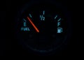 The fuel gauge on the black background showing that the tank is almost empty and it is  time to refuel Royalty Free Stock Photo