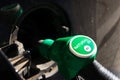 Fuel nozzle with new EU labeling circle gasoline type filling car tank from petrol station dispenser, black car