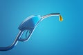 Fuel pistol pump nozzle with petrol drop on blue backdrop. Royalty Free Stock Photo