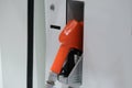 Fuel pump. Detail of a Orange hand holding a fuel pump at a station Royalty Free Stock Photo