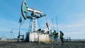 Fuel pumping derrick and two inspectors talking near it