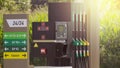 Fuel pumps at a gas station, informations signs. Fuel nozzle in oil dispenser. Petrol gun filling green and golden colors