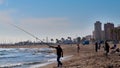 Fuengirola, Spain - April 6, 2019: An angler fishing on the beach on a windy day.