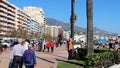 FUENGIROLA, SPAIN - APRIL 7, 2019: People and tourist walking on famous Paseo Maritimo promenade, elder man working out