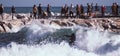 Fuengirola, Spain; December 6, 2019; Young caucasian woman surfs the ocean wave while people watch it