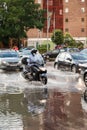 Motorcycle passing through a roundabout flooded by a strong summer storm