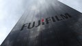 Fujifilm logo on a skyscraper facade reflecting clouds. Editorial 3D rendering Royalty Free Stock Photo