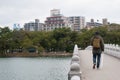 Fukuoka, Japan - January 1, 2019: A man carrying backpack and holding white umbrella walking on the stone bridge in Ohori Park Royalty Free Stock Photo