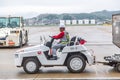 Japanese airport baggage handler, or known as ramper, driving a baggage truck