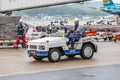 Japanese airport baggage handler, or known as ramper, driving a baggage truck puller