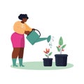 A full African-American woman watering her potted flowers.