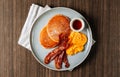 Full American Breakfast butter Pancakes fried Eggs And Bacon and sausages served on white plate on wooden table top view Royalty Free Stock Photo
