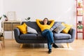 Full angle view of young pretty woman relaxing on cozy sofa with hands over head Royalty Free Stock Photo