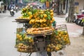 Full basket of orange fruit on vendor bike on Hanoi street, Vietnam