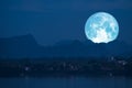 full Beaver Moon back on mountain and reflection on river in the night sky