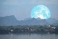 full Beaver Moon back on mountain and reflection on river in the night sky