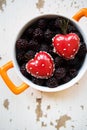 A full blackboy plate with a dessert in the form of a heart stands on a wooden background, close-up