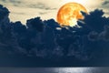 Full blood moon over silhouette heap cloud on the sea Royalty Free Stock Photo