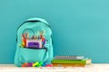 Full blue School Backpack with different supplies on blue background. Concept back to school Royalty Free Stock Photo