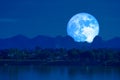 Full blue worm blue moon rise back silhouette mountain blur dark cloud on the night sky