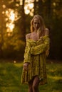 Blond woman resting in forest at sunset