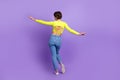Full body cadre of relaxed flying slim woman bob hair wearing stylish crop top open spine with jeans isolated on purple Royalty Free Stock Photo