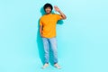 Full body cadre of young friendly man orange t shirt jeans white sneakers stylish outfit waving palm hi isolated over Royalty Free Stock Photo