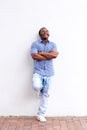 Full body happy black man leaning against wall and laughing Royalty Free Stock Photo