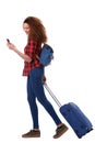 Full body happy travel woman walking with cellphone and luggage against isolated white background Royalty Free Stock Photo
