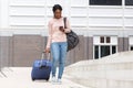 Full body happy young african american woman walking with suitcase bag and cellphone Royalty Free Stock Photo