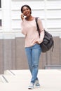 Full body happy young black woman walking and talking with mobile phone Royalty Free Stock Photo