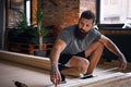 Carpenter measuring boards in a room with loft interior.